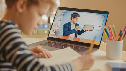 Smart Little Boy Uses Laptop for Video Call with His Teacher. Screen Shows Online Lecture with...
