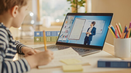 Smart Little Boy Uses Laptop for Video Call with His Teacher. Screen Shows Online Lecture with...