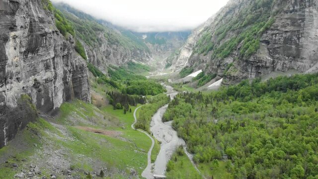 Cirque du Fer a Cheval in French Alps aerial drone video, beautiful alpine valley with high cliffs river and forest in Sixt Fer-a-Cheval in Haute-Savoie France, touristic scenic hike, 4k 60fps