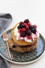 Stack of oatmeal pancakes topped with hazelnut paste and blueber