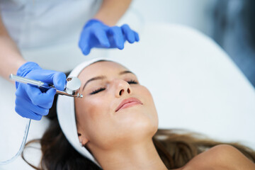 Fototapeta premium Beautiful young woman getting face treatment at beauty salon.