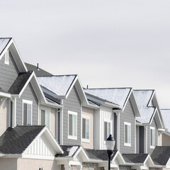Square Facade of townhouses in South Jordan Utah with snowy gable roofs in winter