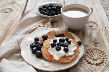 Healthy breakfast concept. Oatmeal pancakes topped with yogurt and blueberries.