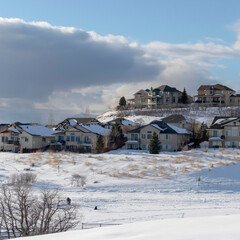 Fototapeta na wymiar Square Wasatch Mountain in winter with houses on sunlit acres of snow covered terrain