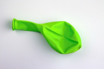 Uninflated green balloon isolated on white background.Green Inflatable balloon not inflated on white backdrop.