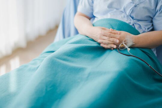 Hand of Young elderly patient sitting in bed at hospital which smiling and felling happy. Medicine and health care safe concept.