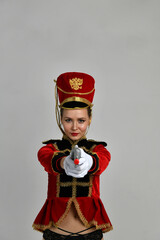 beautiful girl in an old hussar costume and in black boots and with a gun