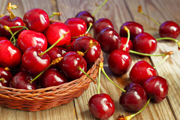 Ciliegie mature appena raccolte su tavolo di legno grezzo.