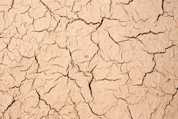Old cracked wall made of orange clay and straw.