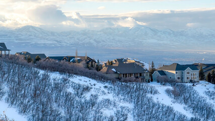 Panorama Houses on snowy mountain overlooking Wasatch Mountains and residential valley