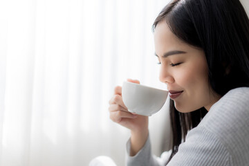 Close up young beautiful woman enjoy drinking with cup of coffee or tea near the window.