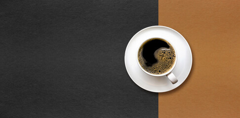 cup of coffee on black and brown paper background.