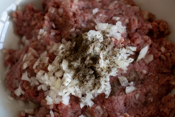 minced in a food processor. Minced meat in a container with onions. Stuffed meat with chopped onions