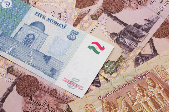 A close up image of a five somoni bank note from Tajikistan in macro with a background of Egyptian one pound bank notes
