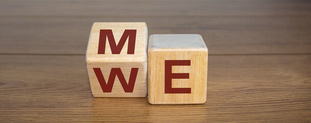 Expanded wood cube with me or we words on wooden background, copy space.