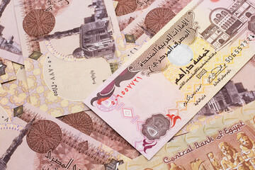 A close up image of a five dirham bank note from the United Arab Emirates on a background of Egyptian one pound bank notes in macro