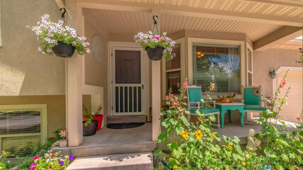 Panorama Home exterior with bay window on front porch decorated with flowers and plants