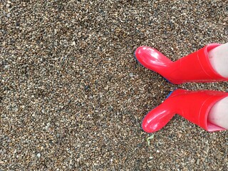 Red plastic boots on gravel