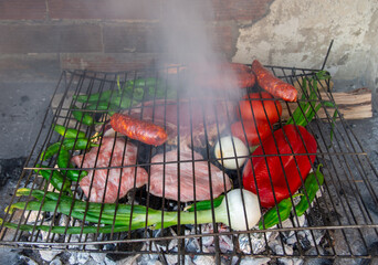 Vegetables, meat and sausages made on a charcoal grill. Barbecue with family and friends.