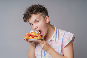 Funny girl with cake on gray background