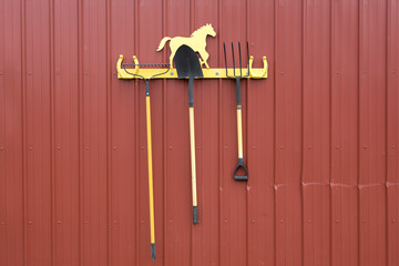 Rake, shovel, and pitchfork on a rack.