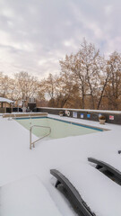 Vertical Snow covered recliner beds around a pool