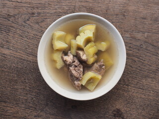 Top view bitter melon and pork bone soup on wooden background