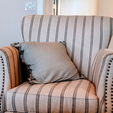 Square Frame Striped Armchair With Fringed Throw Pillow Inside Living Room With Wooden Floor