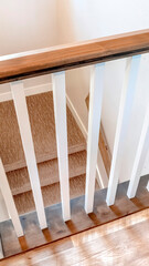 Vertical Looking down on U shaped indoor staircase with white baluster and brown handrail