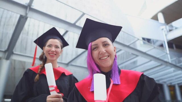 Two happy female students are celebrating her graduation 