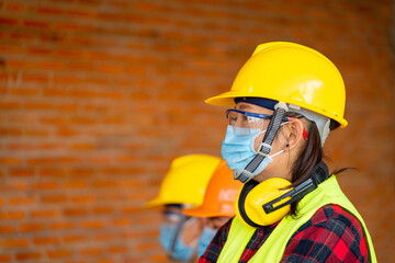 Engineer wearing protective mask working at construction site,Quarantined masked workers protect spreading of Covid 19 by wearing face masks.