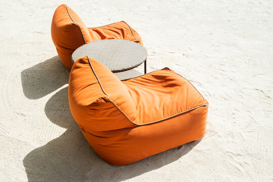 Bean bags and table on the sand tropical beach. Vacation and summer holidays concept.