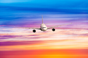 Fototapeta na wymiar Passengers commercial airplane flying above clouds in sunset light.