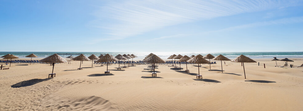 Beach umbrellas on the the beautiful unique sand beach. Vacation and summer holidays concept. Banner and panoramic edition.