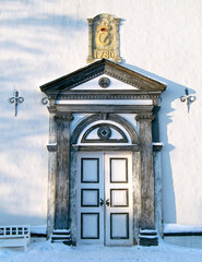 The entrance door to the old Roros (Røros) church lit by a low winter sun.