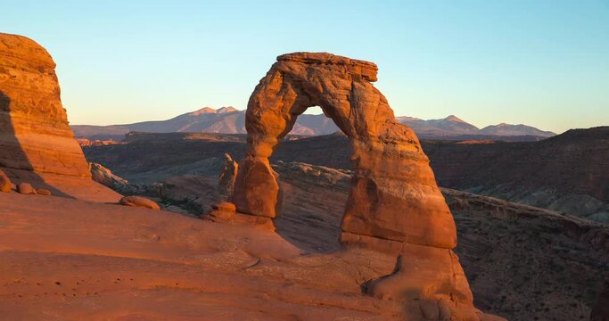 Time lapse shot of tourists at famous Delicate Arch in desert against sky during sunset - Arches National Park, Utah