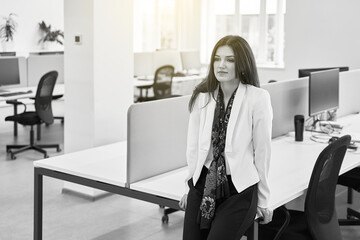 Thoughtful confident caucasian business woman or manager alone in modern office. Black and white.