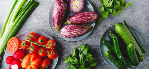 Green, red and purple various fresh vegetables on a table. Healthy eating concept. Flat lay, top view.