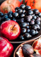 Autumn food, red apples, figs, grapes and pumpkin.