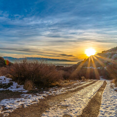 Square Snowy dirt road in Provo Canyon overlooking lake mountain and sun at sunset