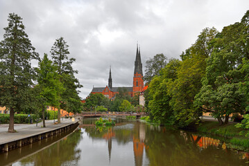 Fototapeta premium Uppsala Cathedral and its reflection in Fyris river. Uppsala, Sweden