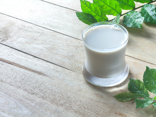 White milk in a glass on the old wooden table.
