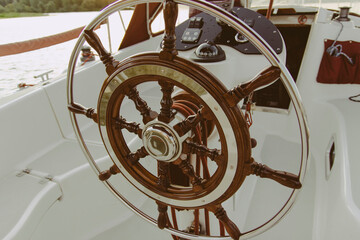 Round retro helm on a yacht. Weekend trip on the lake 
