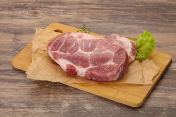 Raw pork steak over wooden board