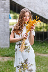 A girl in a light summer dress with a bouquet of yellow flowers, on the street