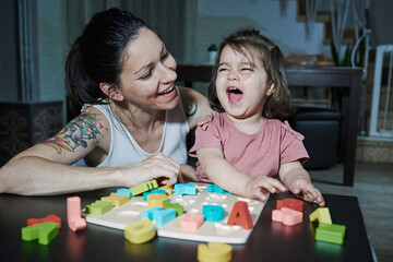 A mother teaching her daughter the letters of the alphabet