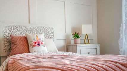 Panorama frame Bedroom with feminine beddings and decorative headboard against panelled wall
