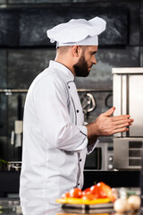 Chef man prepare vegetables at kitchen restaurant. Chef in uniform at kitchen.