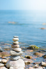 Pebble pyramid in the sunny day.On the sea shore a pyramid of stones. Dream on the beach.