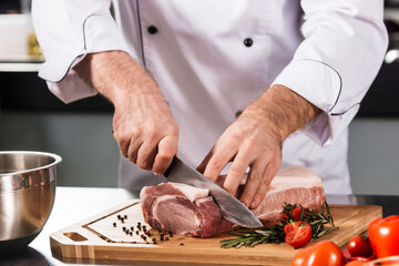 Chef hands cut beef at kitchen restaurant. Closeup chef hands cutting beef.